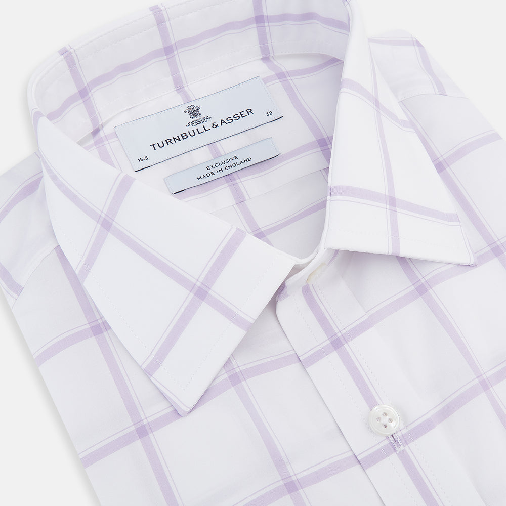 The Turnbull & Asser Lilac Grid Check Mayfair Shirt is a long-sleeve, button-up style crafted from Italian cotton with a white base and lilac grid check pattern, shown on a plain white background.