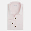 View 5 of product The Soft Pink Hyde Overshirt by Turnbull & Asser features long sleeves, sanforised cotton, dark buttons, and a left front pocket, shown laid flat on a white background.