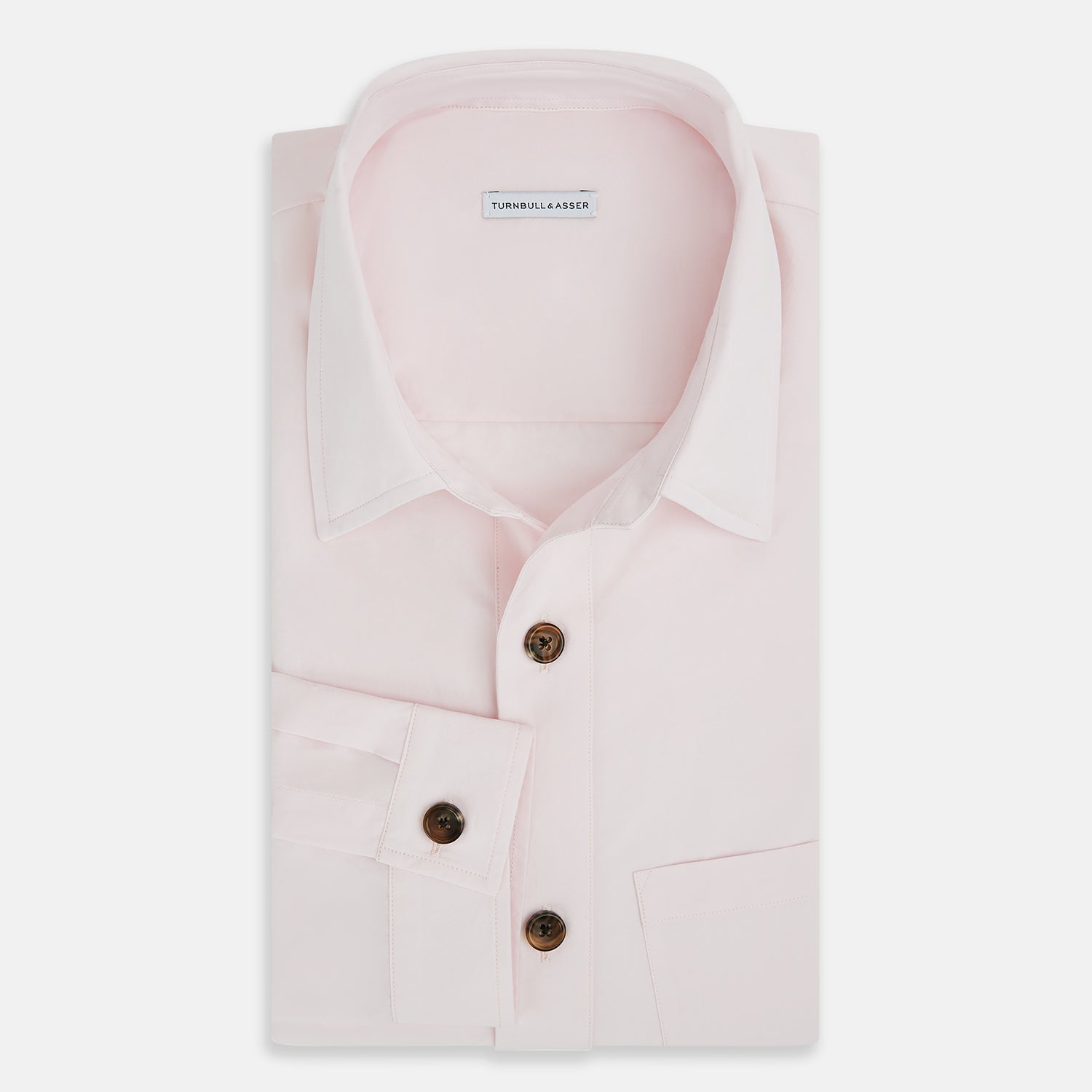 View 5 of product The Soft Pink Hyde Overshirt by Turnbull & Asser features long sleeves, sanforised cotton, dark buttons, and a left front pocket, shown laid flat on a white background.