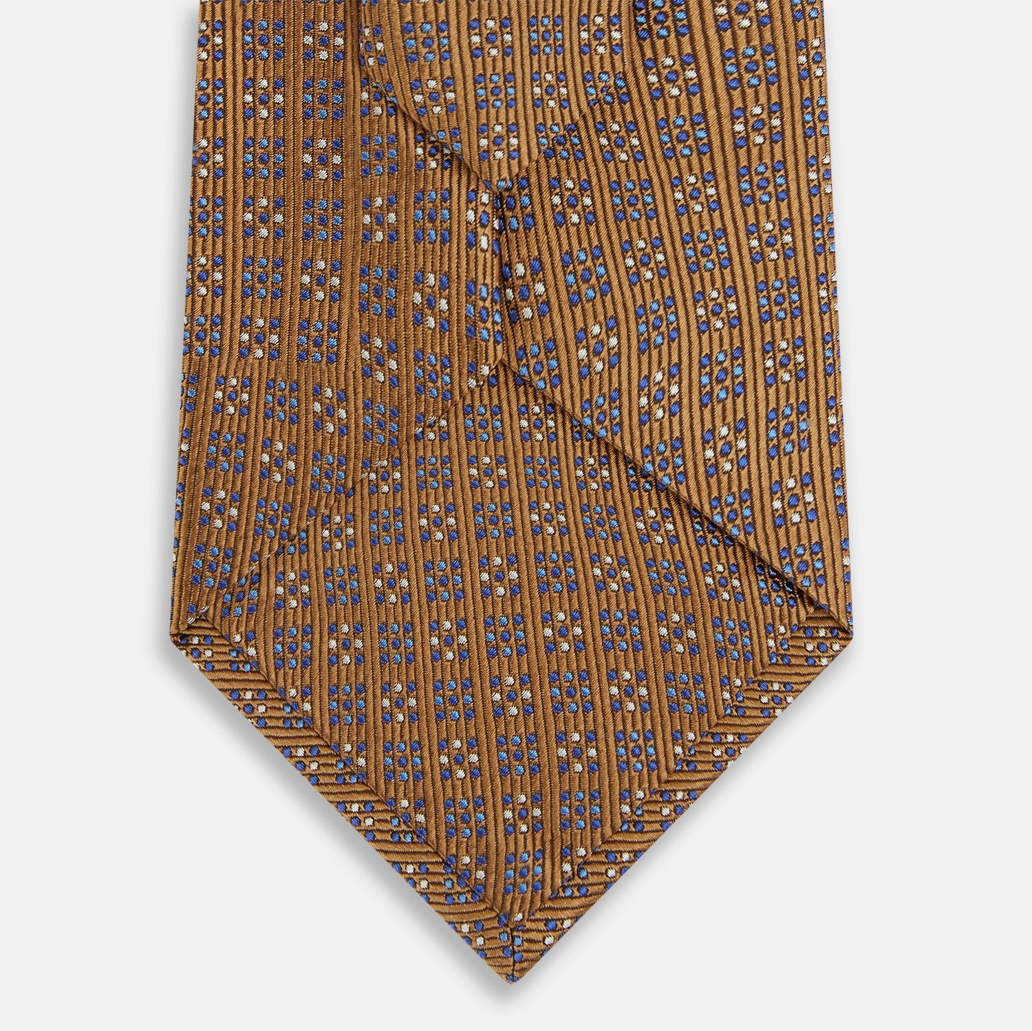 View 3 of product The Turnbull & Asser Tan and Blue Multi Dot Silk Tie is rolled up, showcasing a refined dotted pattern on silk—an elegant accessory ideal for elevating modern office attire.
