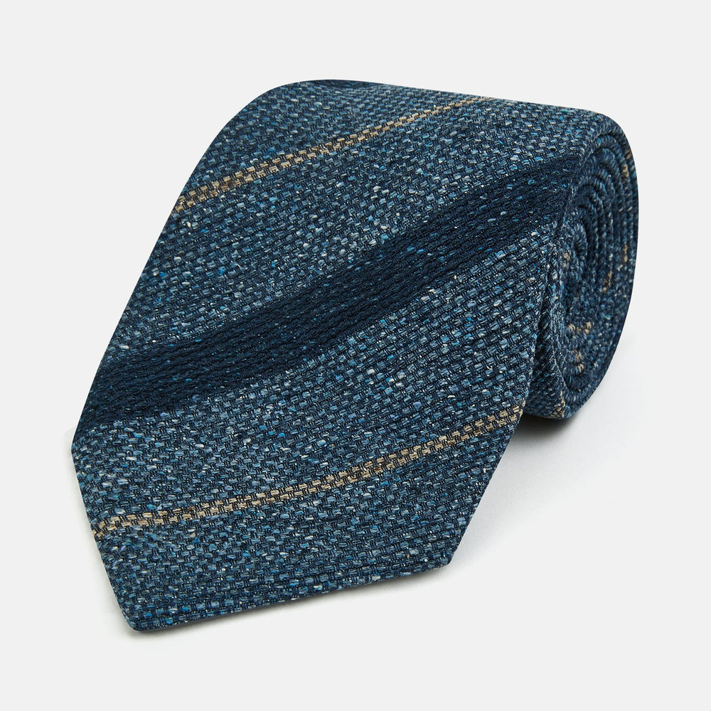 The Blue Multi Stripe Silk Tie by Turnbull & Asser, featuring navy and cream stripes on blue English silk, is shown rolled up against a white background.