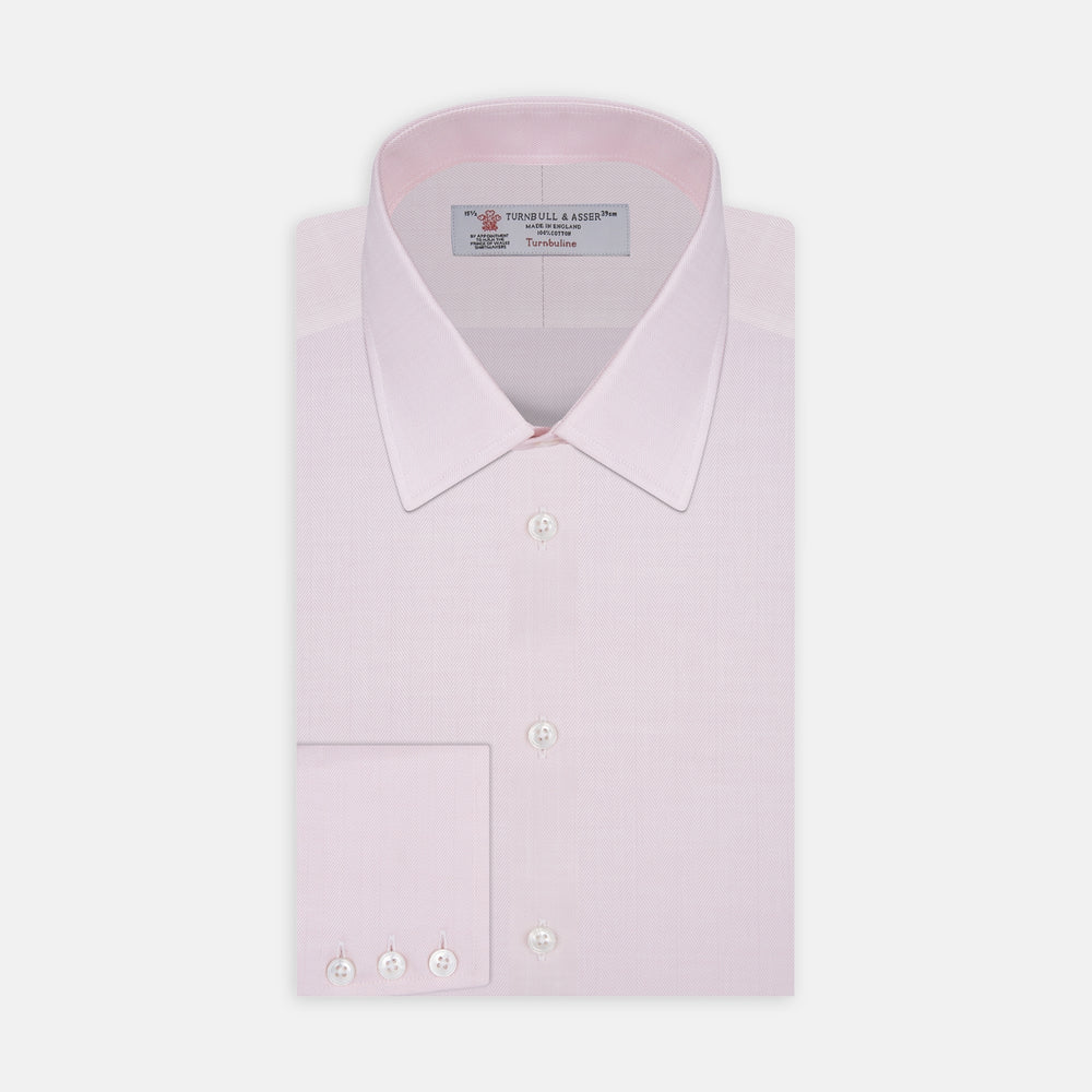 A Pink Herringbone Superfine Cotton Shirt by Turnbull & Asser, featuring a T&A collar and 3-button cuffs, is neatly folded with the inner collar label visible and white buttons, set against a plain white background.
