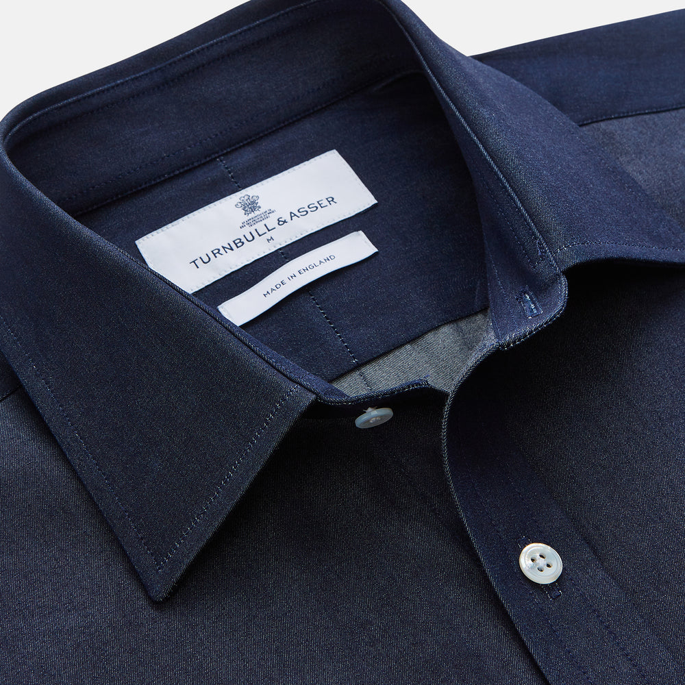The Turnbull & Asser Blue Weekend Fit Finch Shirt features a Derby collar, chest pocket, classic white buttons, and timeless style, all in cotton. Laid flat on a white background.