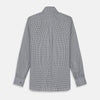 View 5 of product A person with a shaved head models the Turnbull & Asser Grey Check Weekend Fit Flannel Shirt with a Derby collar and 1-button cuffs, sleeves rolled up, paired with dark trousers against a plain background, gazing directly at the camera.