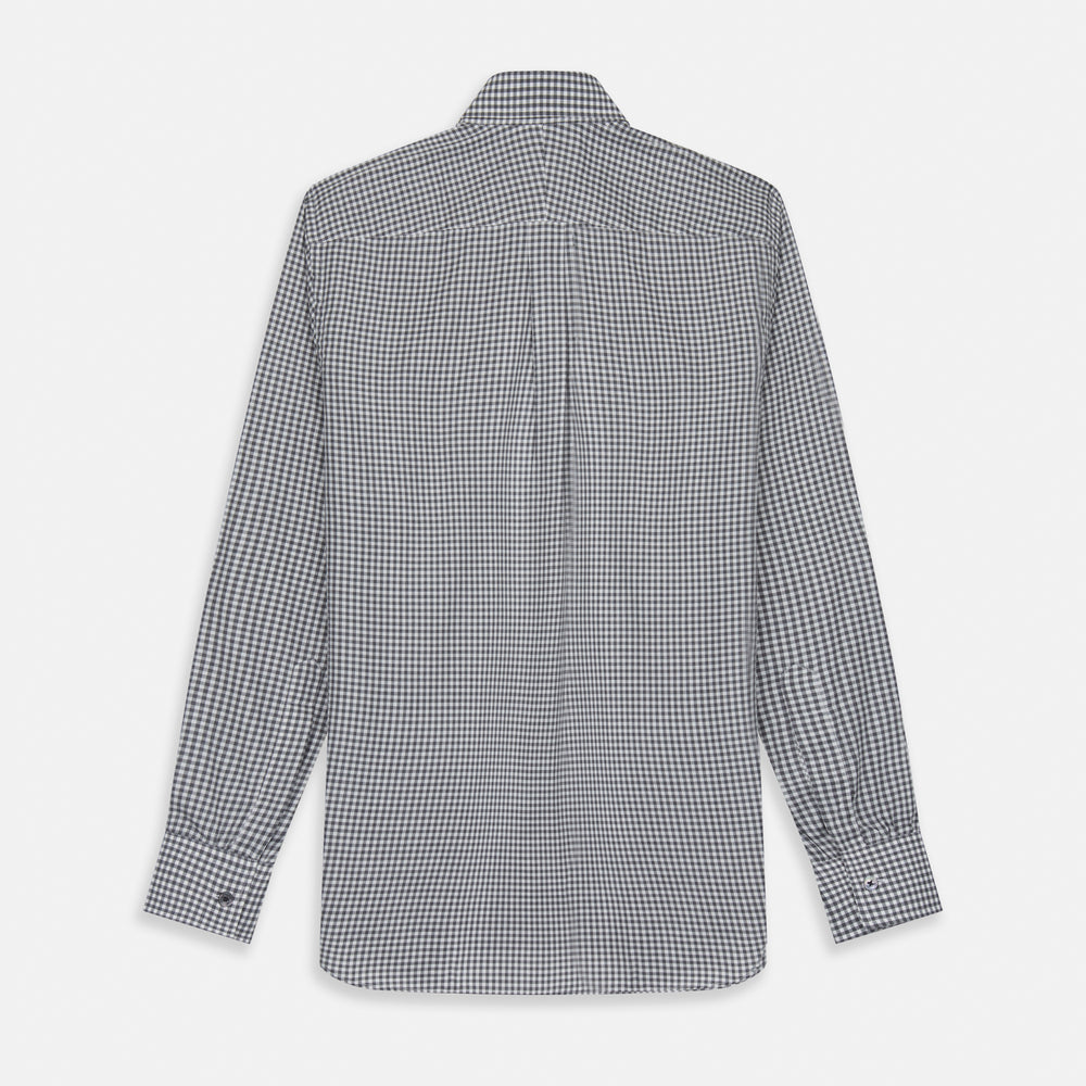 A person with a shaved head models the Turnbull & Asser Grey Check Weekend Fit Flannel Shirt with a Derby collar and 1-button cuffs, sleeves rolled up, paired with dark trousers against a plain background, gazing directly at the camera.