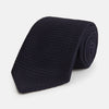 View 1 of product The GRENADINE NEW NAVY TIE by Turnbull & Asser features a dark navy blue woven texture, making it the perfect accessory for refined looks. Displayed against a plain white background.