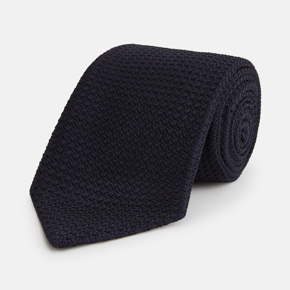 The GRENADINE NEW NAVY TIE by Turnbull & Asser features a dark navy blue woven texture, making it the perfect accessory for refined looks. Displayed against a plain white background.