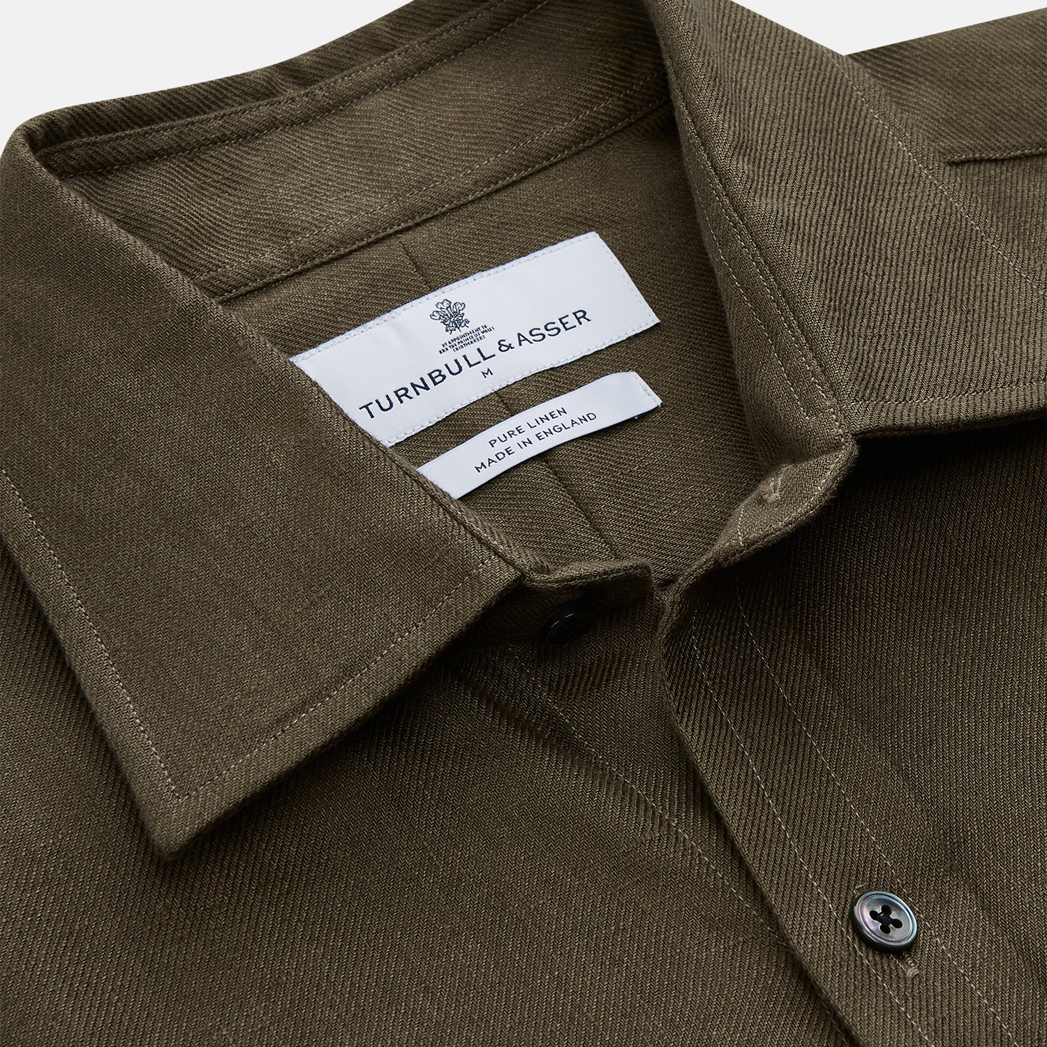 View 2 of product The Turnbull & Asser Khaki Green Linen Weekend Fit Langston Shirt features long sleeves, a classic Derby collar, two chest pockets, and buttoned cuffs, shown against a white background.