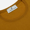 View 2 of product The Turnbull & Asser Gold Crew Neck Merino Jumper, featuring long sleeves and ribbed cuffs and hem, is displayed flat on a white background.