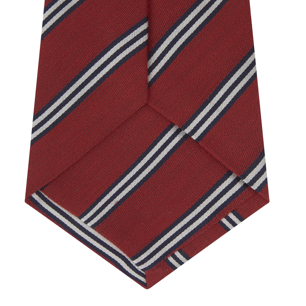 The Turnbull & Asser GGT92000 3042 48 OS is a rolled-up red cotton silk stripe tie with diagonal white and navy blue stripes, displayed on a plain white background.