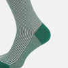 View 4 of product Turnbull & Asser Melon Green/White Thin Striped Long Sock features melon green and white vertical stripes with a solid green toe, heel, and cuff, shown singly against a plain light background.