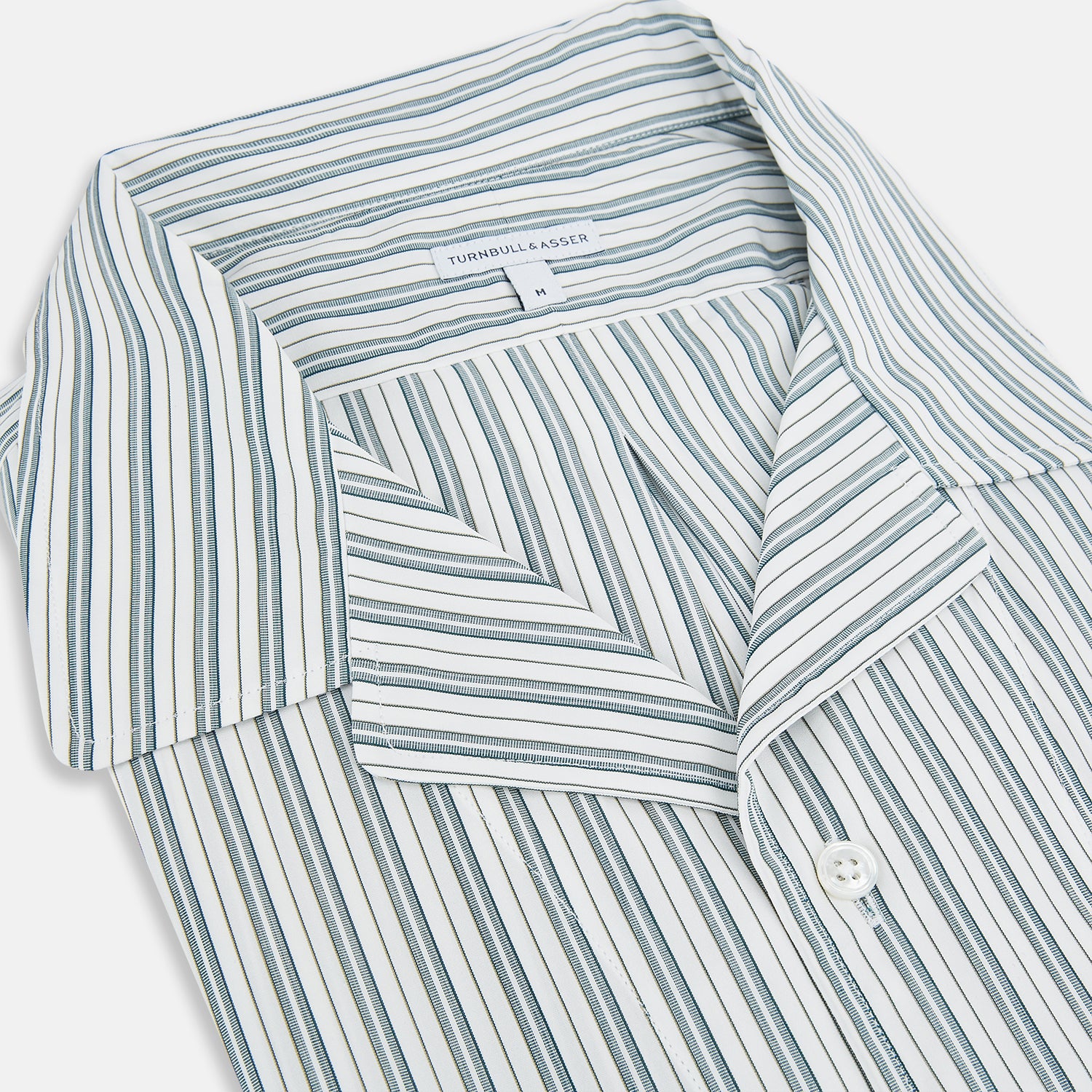 View 2 of product The Green Double Stripe Quarzo Nightshirt by Turnbull & Asser is a relaxed-fit, long-sleeve, knee-length Italian cotton shirt dress with a collar, partial button-down front, chest pocket, and buttoned cuffs in green and white stripes.