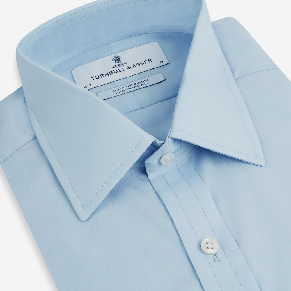 The Turnbull & Asser Light Blue Sea Island Quality Cotton Shirt features a T&A collar, long sleeves, and 3-button cuffs, beautifully displayed flat on a white background.