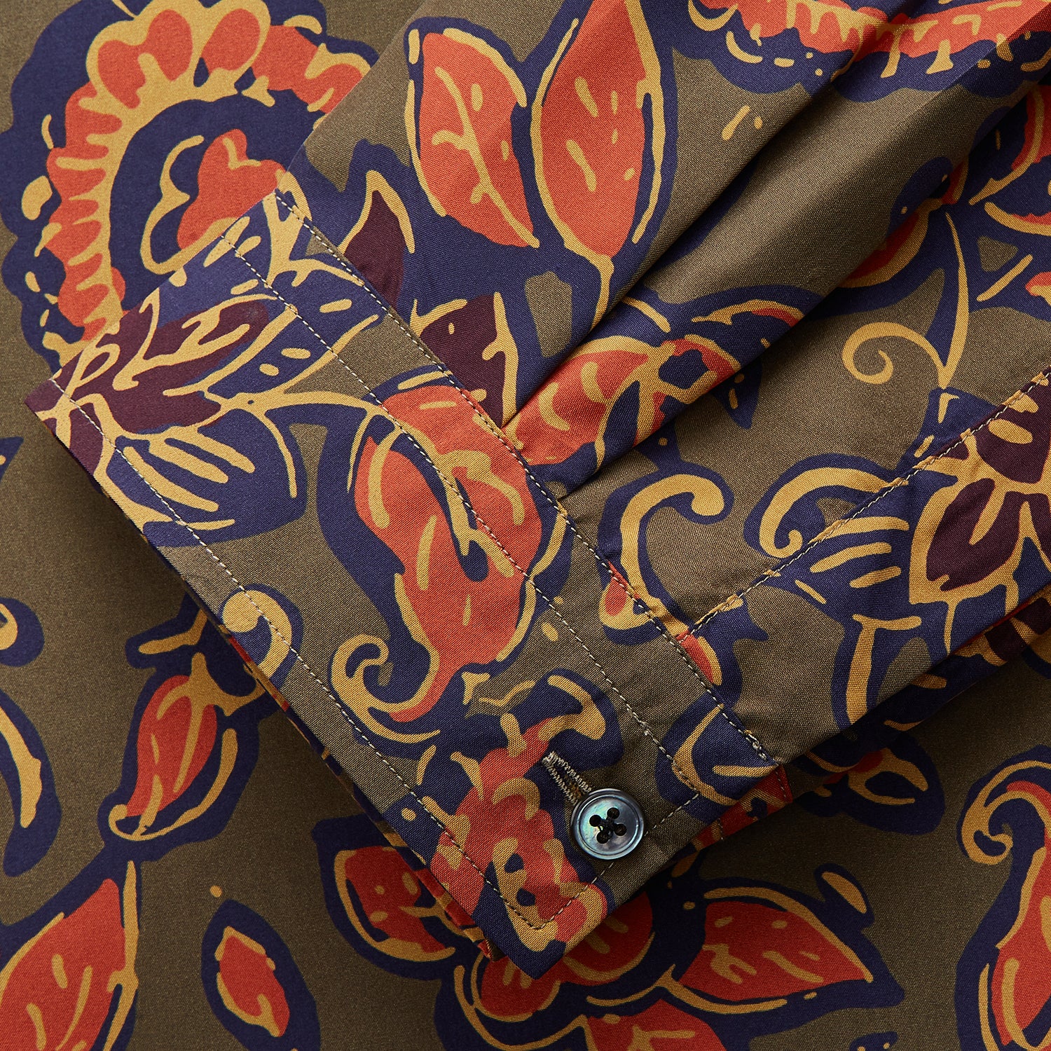 View 2 of product The Turnbull & Asser Khaki Green Floral Silk Holiday Fit Winnington Shirt features a bold floral print with orange, yellow, and purple on an olive background, plus a spread collar and chest pocket for versatile style.