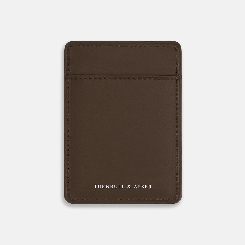 The Dark Chocolate Two-slot Card Case by Turnbull & Asser features slim Italian leather, subtle stitching, and white embossed branding at the bottom center—a refined minimalist accessory on a plain white background.