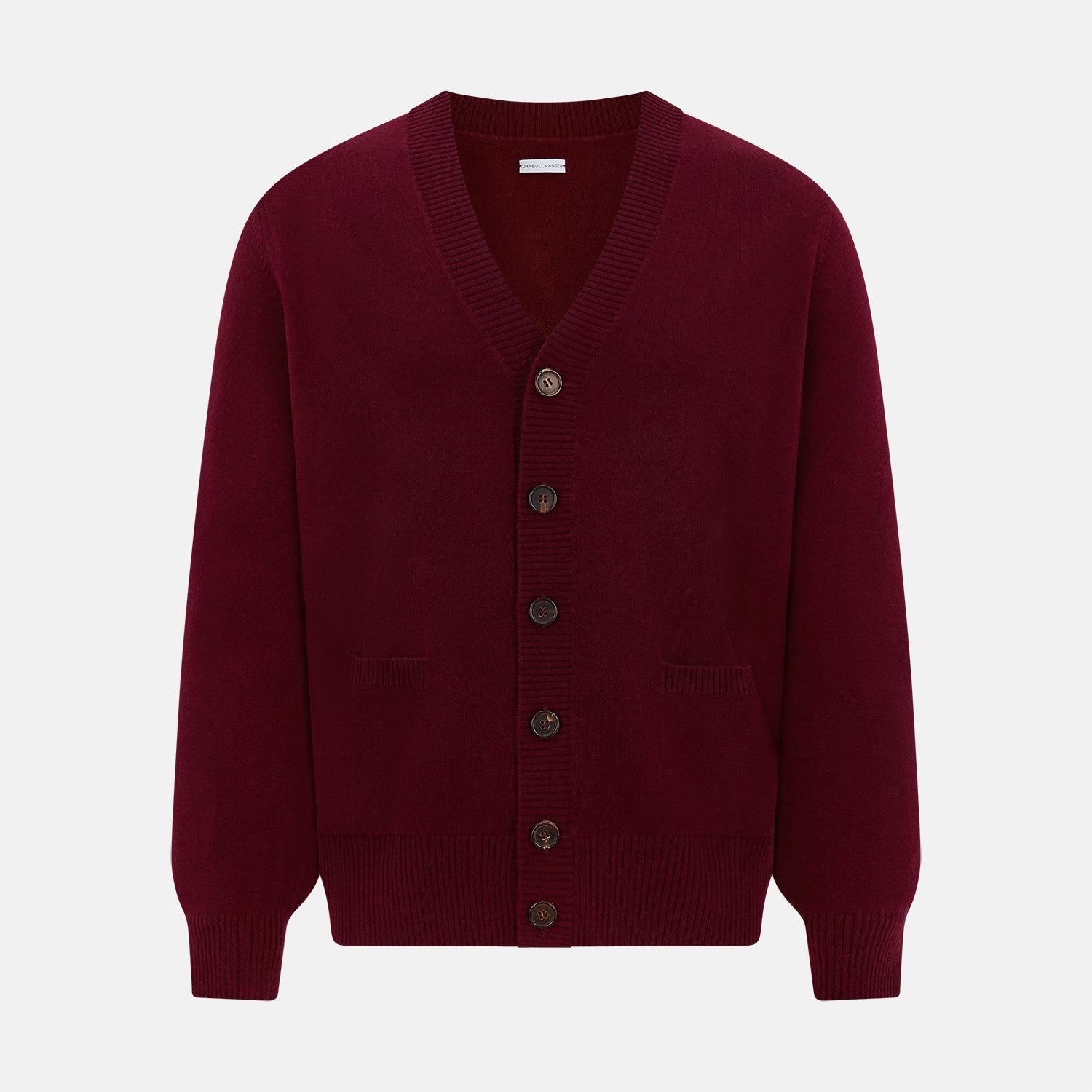View 1 of product The Turnbull & Asser Burgundy Cashmere Cardigan features a V-neck, ribbed cuffs and hem, two front pockets, and a classic button-up design, shown on a plain white background.
