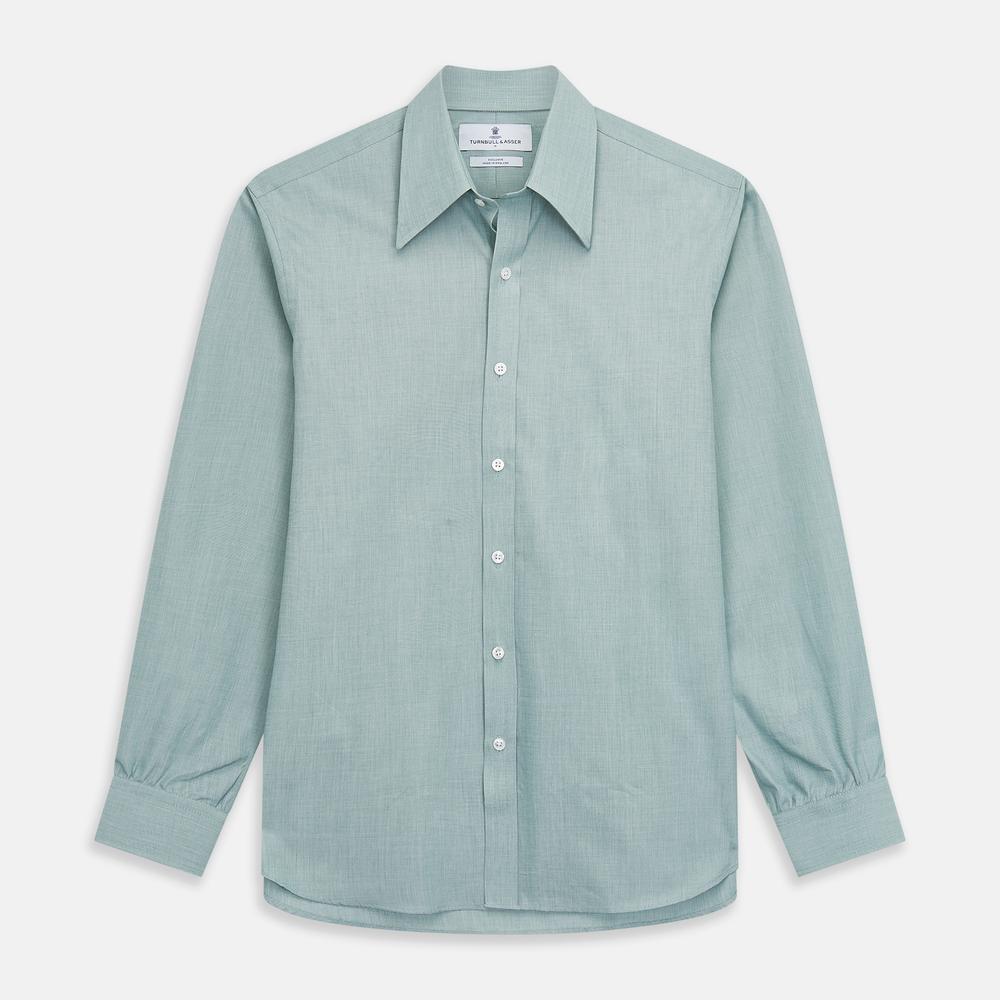 Close-up view of Plain Green Cotton Fabric by Turnbull & Asser, highlighting fine diagonal weave and texture, framed within a circular border on a white background.