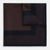 View 1 of product The Navy and Blush Dot Silk Pocket Square by Turnbull & Asser features a navy base with small orange polka dots and a border, shown neatly folded with one corner flipped over.
