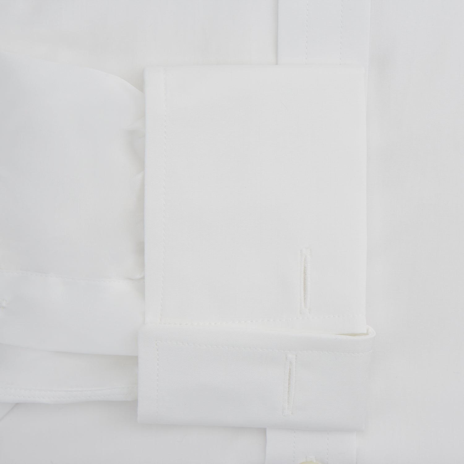 View 3 of product The Turnbull & Asser White Sea Island Quality Cotton Shirt features a T&A collar, double cuffs, and long sleeves, displayed against a white background.