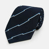 View 1 of product The Turnbull & Asser Navy Broken Shadow Stripe Silk Tie features British excellence with a light blue and white zigzag pattern and is shown rolled up on a plain white background.