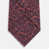 View 3 of product A rolled-up Turnbull & Asser Orange Paisley Silk Tie, featuring an elegant pattern, is displayed against a plain white background.