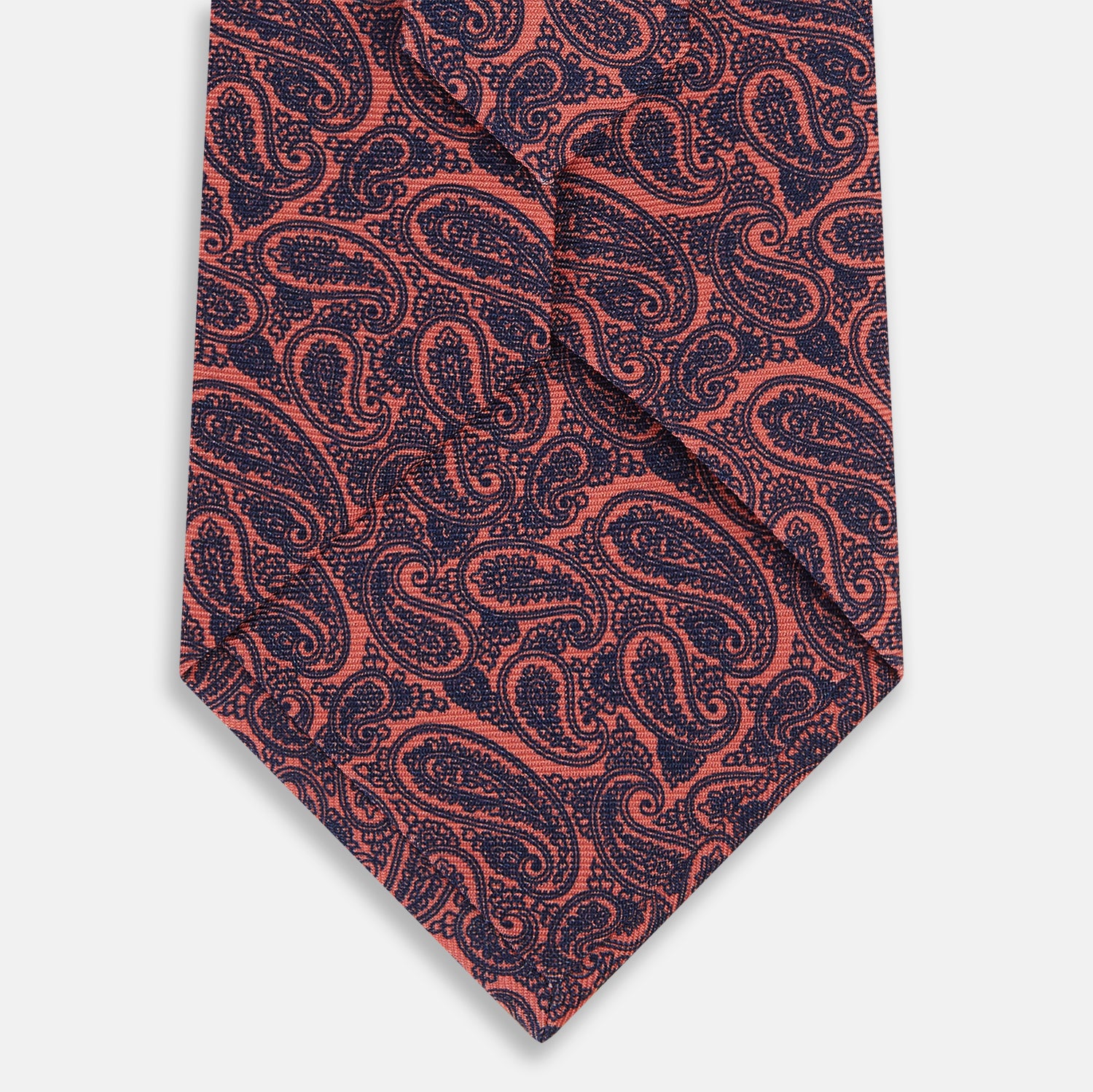 View 3 of product A rolled-up Turnbull & Asser Orange Paisley Silk Tie, featuring an elegant pattern, is displayed against a plain white background.