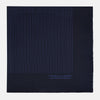 View 4 of product The Navy Stripe Silk Pocket Square by Turnbull & Asser features a dark navy silk with thin light blue stripes and hand-rolled edges, folded to reveal both sides and “TURNBULL & ASSER HAND PRINTED IN ENGLAND” in the corner.