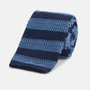 View 1 of product The Turnbull & Asser Navy and Blue Square tipped knitted tie features horizontal stripes and a rolled-up silk design, elegantly displayed on a plain white background.