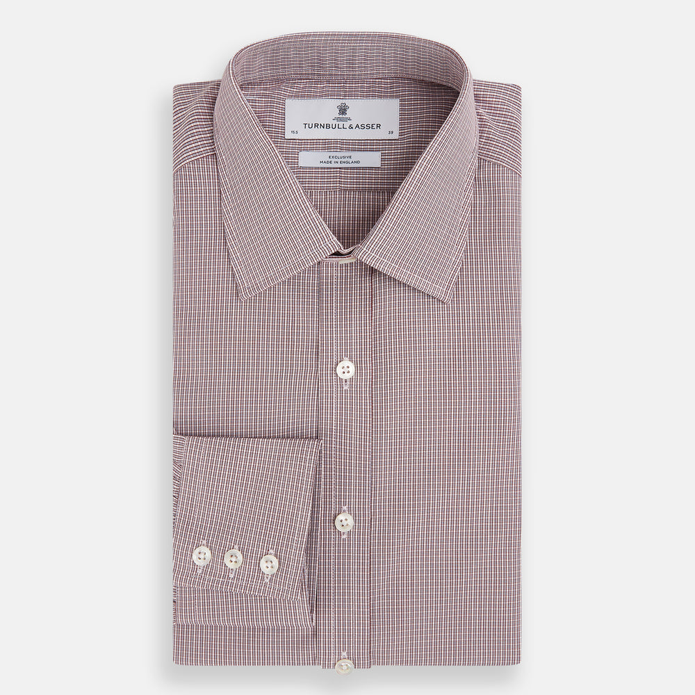 The Turnbull & Asser Burgundy Micro Shadow Check Mayfair Shirt features long sleeves, a classic collar, and white buttons. In light red and white shades, this button-up is perfect for formal wear and is shown laid flat against a white background.