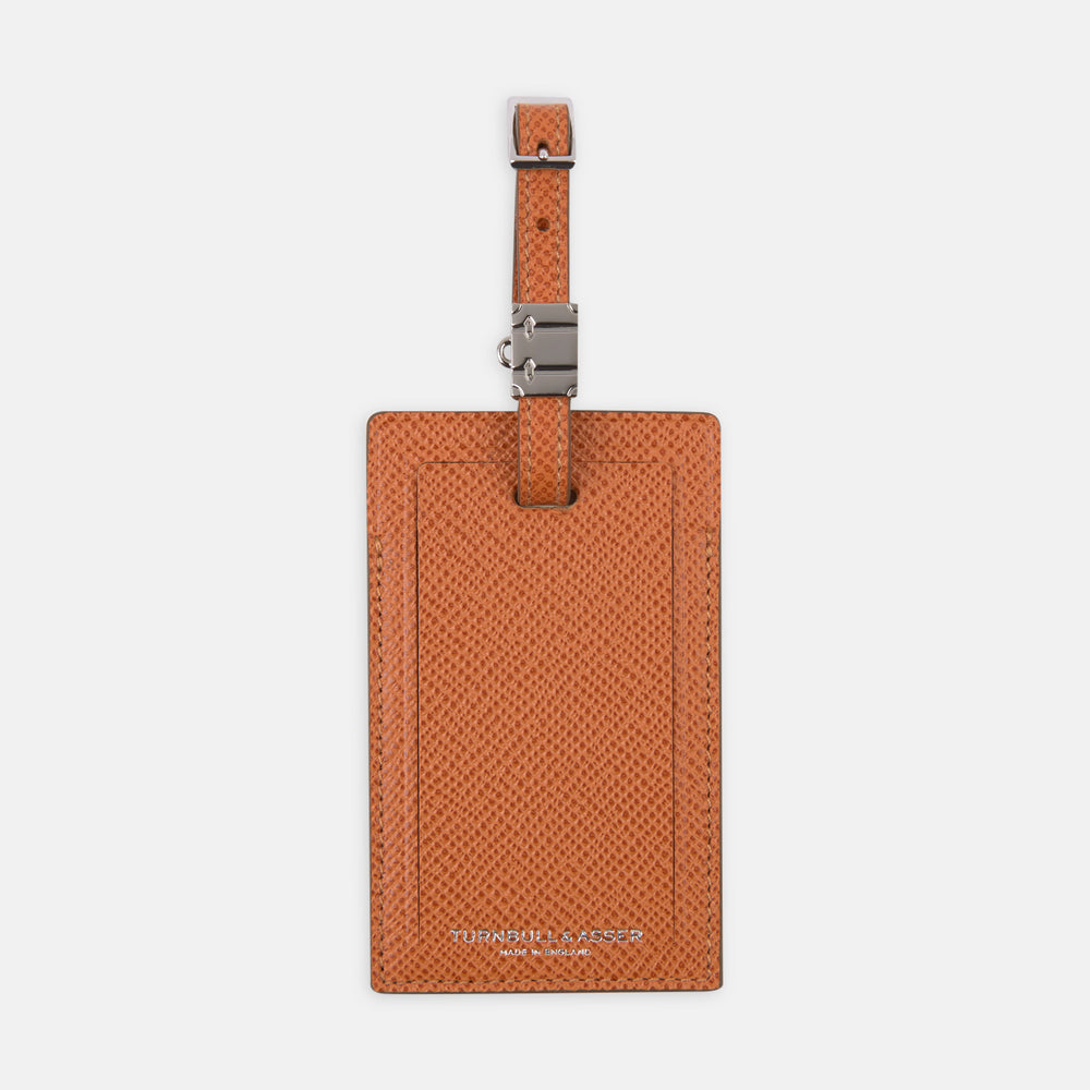 The Brown Leather Luggage Tag by Turnbull & Asser features textured brown leather, a silver buckle strap, and the Turnbull & Asser name embossed in silver at the bottom.