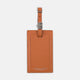 The Brown Leather Luggage Tag by Turnbull & Asser features textured brown leather, a silver buckle strap, and the Turnbull & Asser name embossed in silver at the bottom.