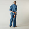 View 4 of product A person stands barefoot against a plain background, wearing the Teal Linen Modern Pyjama Set from Turnbull & Asser.