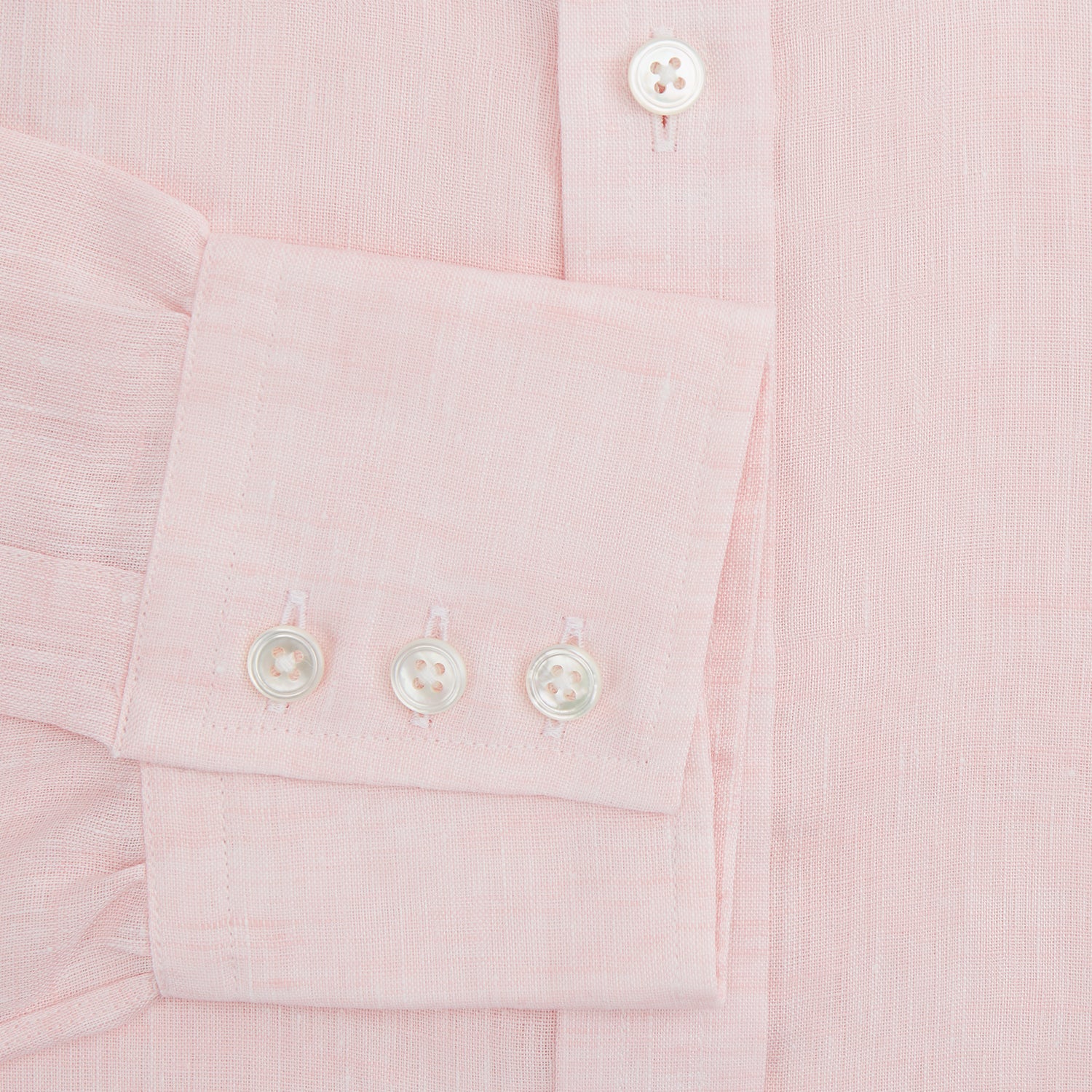 View 4 of product The Turnbull & Asser Pink Linen Shirt features a T&A collar, 3-button cuffs, and classic white buttons. This long-sleeved summer staple is shown on a plain white background.