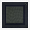 View 4 of product The Turnbull & Asser Navy and Melon Green Dot Silk Pocket Square features small melon green dots on navy silk with a solid border. One corner is folded over to highlight its exquisite handmade craftsmanship.