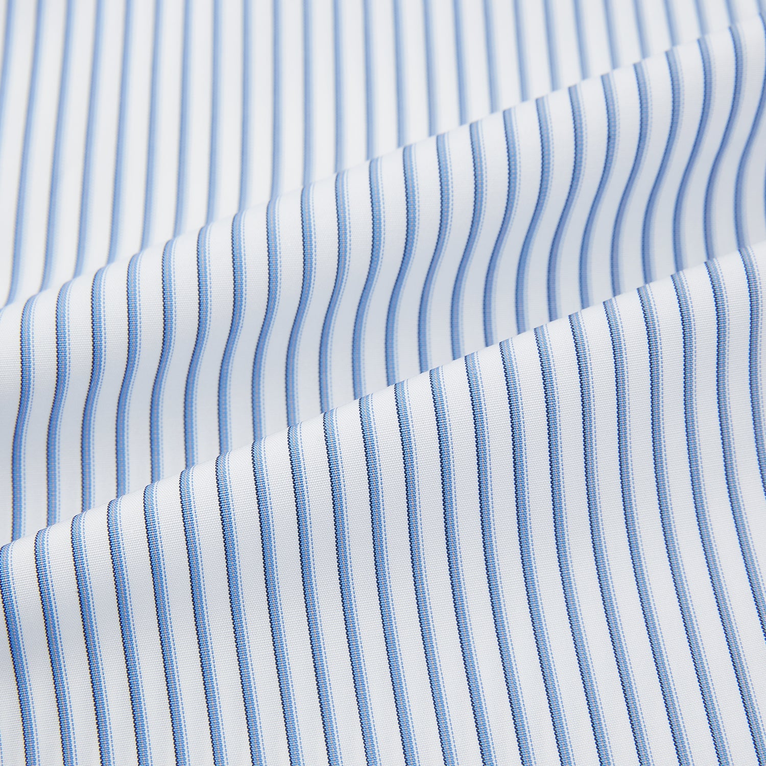 View 6 of product The Turnbull & Asser Blue Shadow Stripe Mayfair Shirt is a long-sleeve button-up with a T&A collar and thin blue vertical stripes on white, shown on a plain white background.