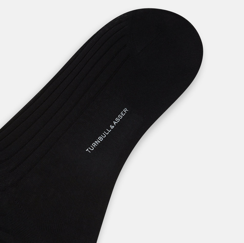 A single Black Cotton Mid-Length Sock by Turnbull & Asser, featuring a ribbed texture and crafted from premium Egyptian cotton, is displayed upright against a plain white background.