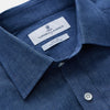 View 2 of product The Blue Weekend Fit Linen Finch Shirt by Turnbull & Asser features a Derby collar, chest pocket, and white buttons. Made from mid-blue linen chambray, it offers effortless casual style when laid flat on a plain white background.