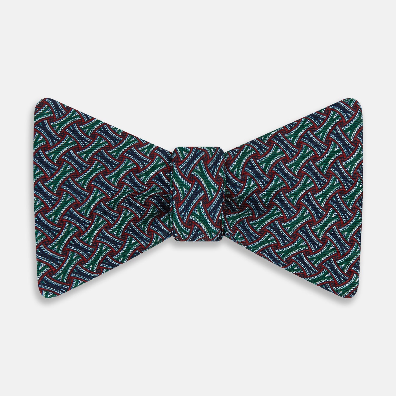 View 1 of product The Forest Green and Red Weave Patterned Silk Bow Tie by Turnbull & Asser features interwoven red, blue, and forest green lines with white dotted accents in a geometric design on a dark background.