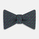 The Forest Green and Red Weave Patterned Silk Bow Tie by Turnbull & Asser features interwoven red, blue, and forest green lines with white dotted accents in a geometric design on a dark background.