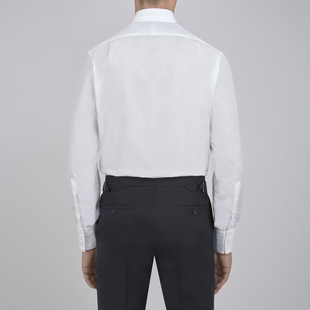 The Sea Island Cotton Classic Fit White Shirt by Turnbull & Asser features a classic collar and front buttons, neatly folded with its label visible, displayed on a light blue background.