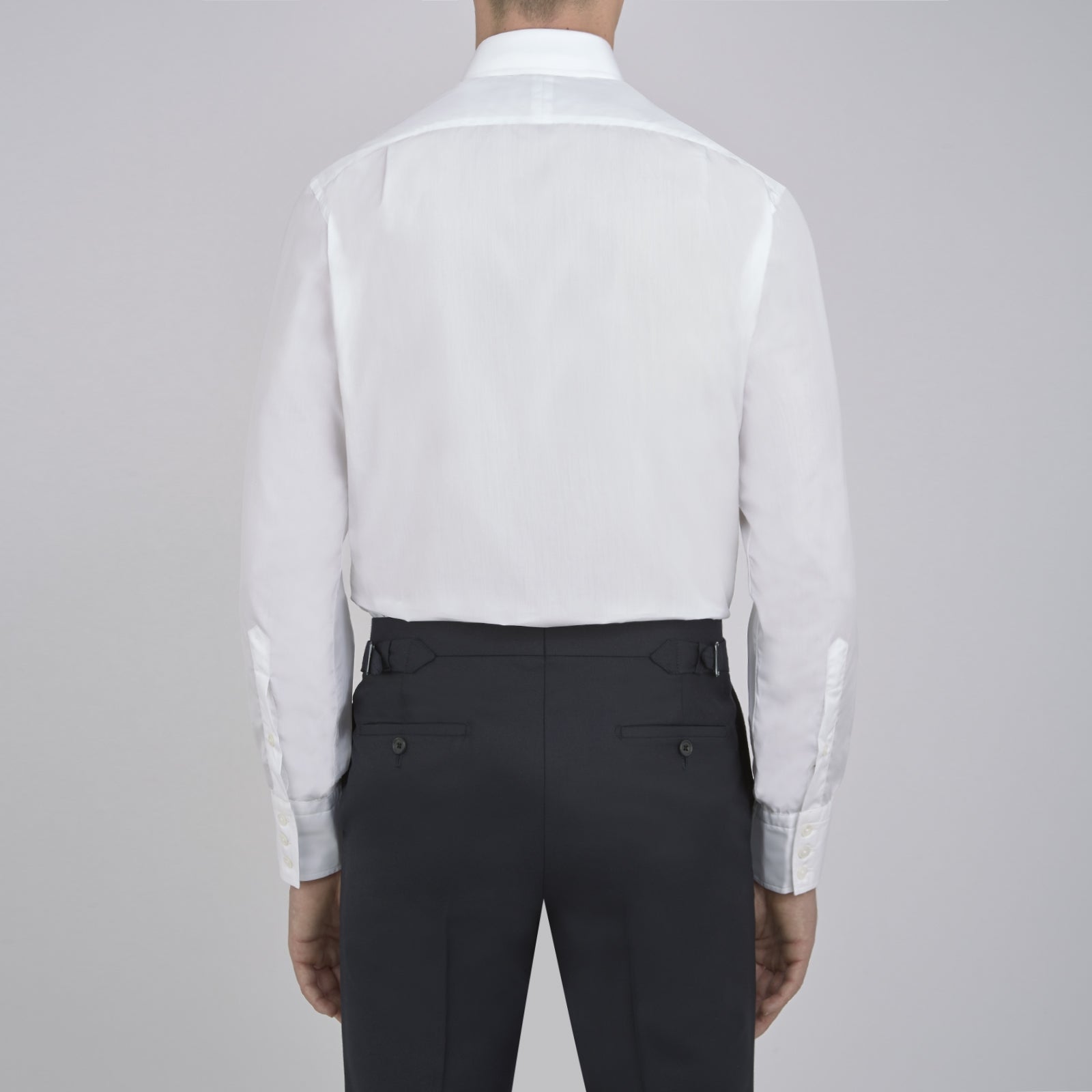 View 3 of product The Sea Island Cotton Classic Fit White Shirt by Turnbull & Asser features a classic collar and front buttons, neatly folded with its label visible, displayed on a light blue background.