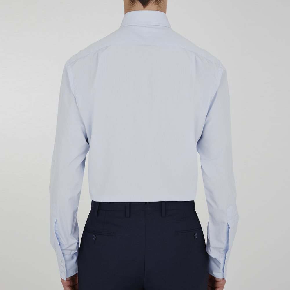 The Turnbull & Asser Two-Fold 120 Light Blue Shirt features a T&A collar, 3-button cuffs, white buttons, front pocket, and inner collar label. It is displayed neatly folded on a plain white background.