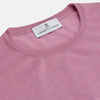 View 3 of product Wearing Turnbull & Asser’s Pink Merino Kingston Crew Neck Jumper, white pants, and a colorful scarf, a person stands against a plain light gray background with hands in their pockets.