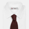 View 2 of product The Turnbull & Asser Burgundy Knitted Tie, rolled and featuring a textured pattern, is displayed on a plain white background—a refined accessory ideal for the modern gentleman’s wardrobe.
