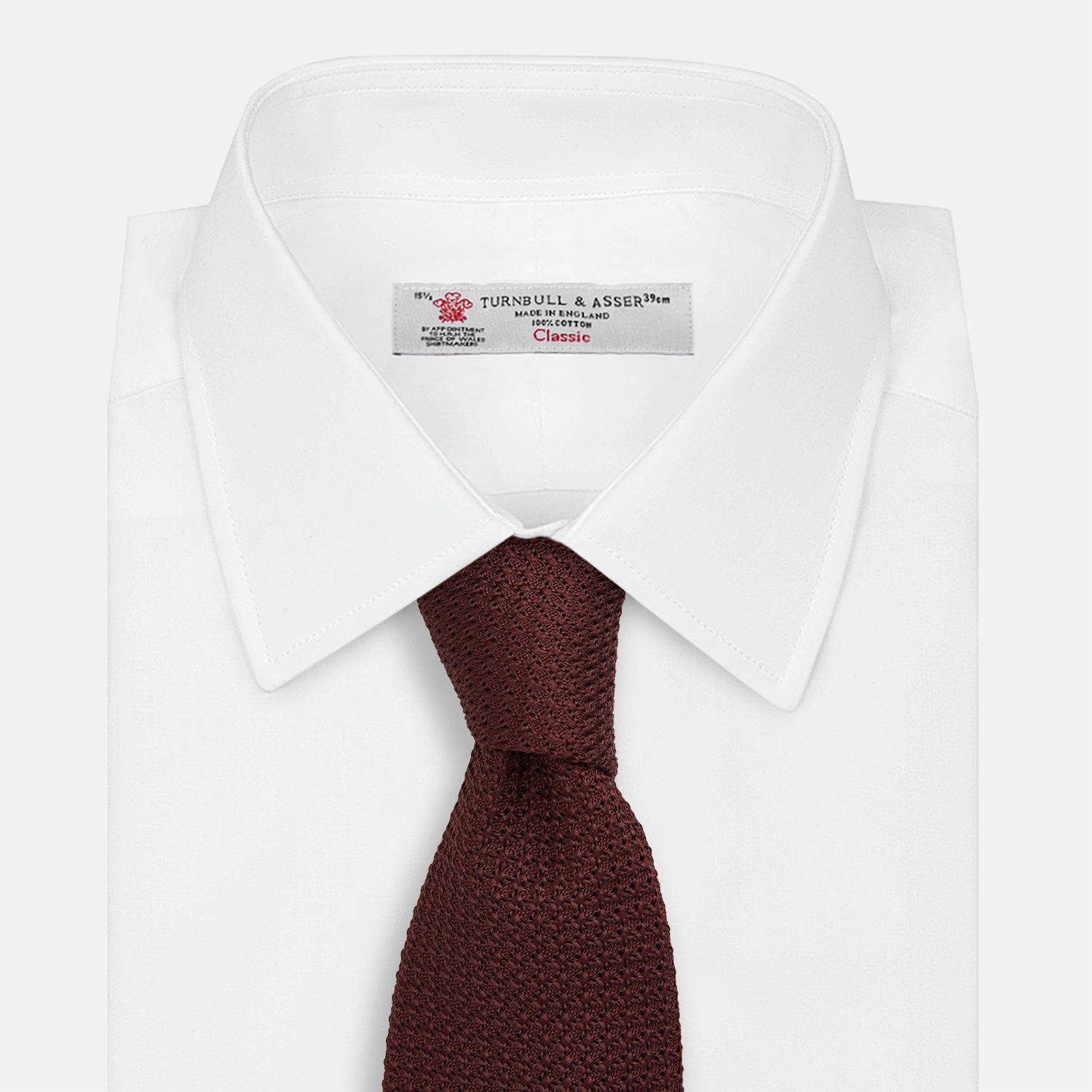 View 2 of product The Turnbull & Asser Burgundy Knitted Tie, rolled and featuring a textured pattern, is displayed on a plain white background—a refined accessory ideal for the modern gentleman’s wardrobe.