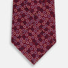 View 3 of product The Turnbull & Asser Pink and Navy Circle Burgundy Silk Tie features a rolled burgundy silk design with small, evenly spaced white, pink, and light blue circle patterns.
