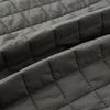 View 4 of product The Turnbull & Asser Shadow Grey Double-Breasted Quilted Gilet features a sleeveless design, asymmetrical collar, side zip pockets, slanted chest pocket, grid pattern, and modern black buttons—perfect for layered dressing.