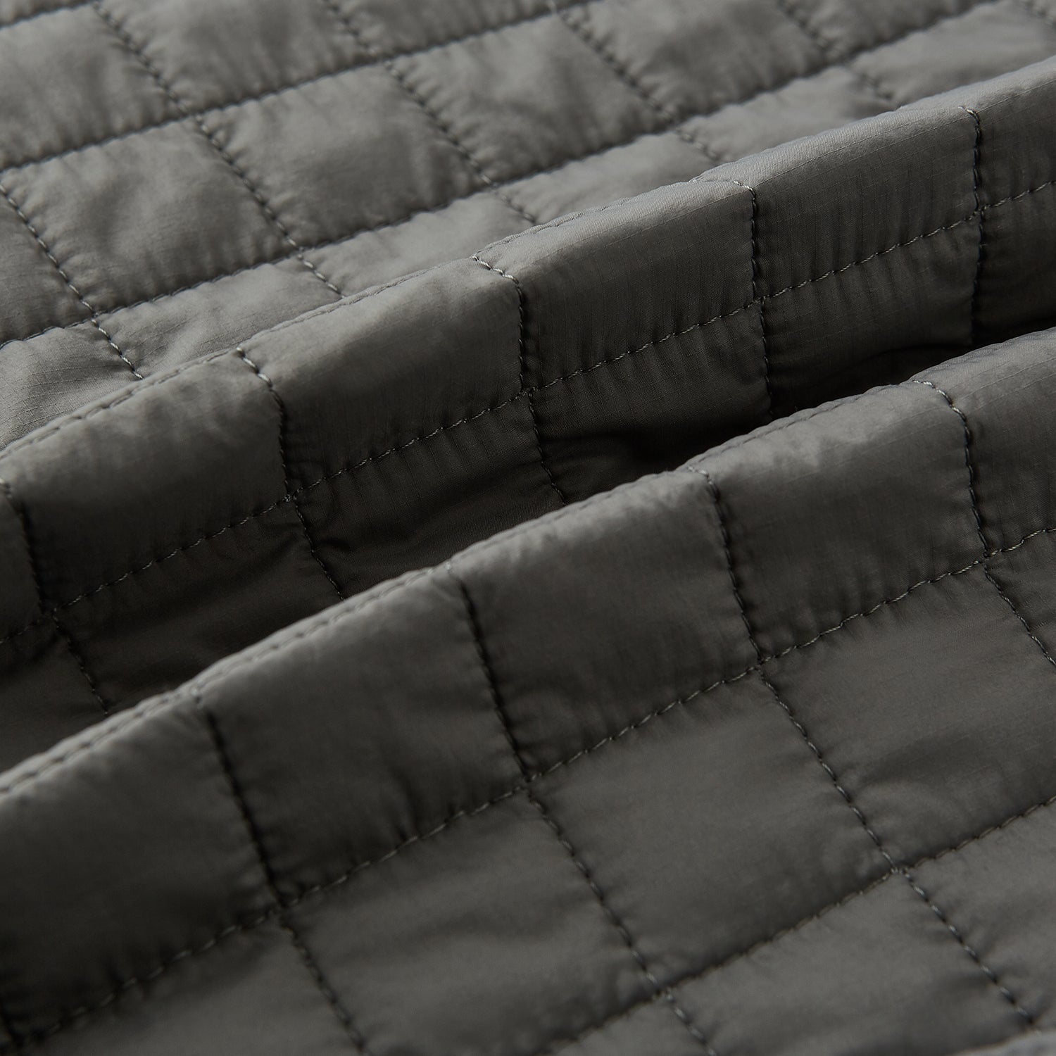 View 4 of product The Turnbull & Asser Shadow Grey Double-Breasted Quilted Gilet features a sleeveless design, asymmetrical collar, side zip pockets, slanted chest pocket, grid pattern, and modern black buttons—perfect for layered dressing.