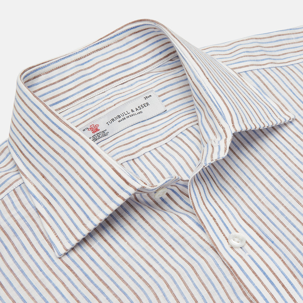 The Turnbull & Asser Brown and Blue Ticking Stripe Linen Shirt features a POW collar and 3-button cuffs, displayed against a light gray surface.