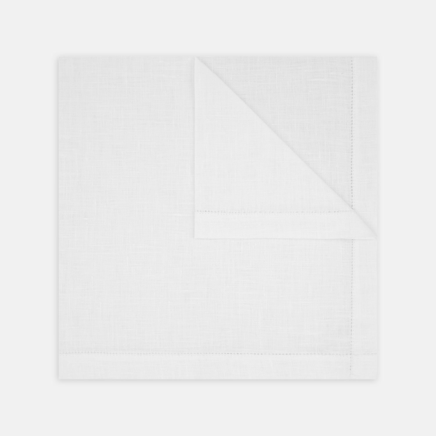 View 1 of product The Turnbull & Asser White Linen Handkerchief, elegantly folded with a corner turned down, evokes classic evening jacket style and is shown against a plain white background.